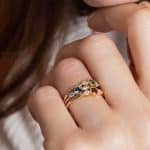 3 bagues Trio Perlés portées serties d'un grenat, une tsavorite et d'un saphir teal adossés à deux diamants ronds