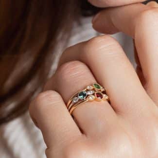 3 bagues Trio Perlés portées serties d'un grenat, une tsavorite et d'un saphir teal adossés à deux diamants ronds