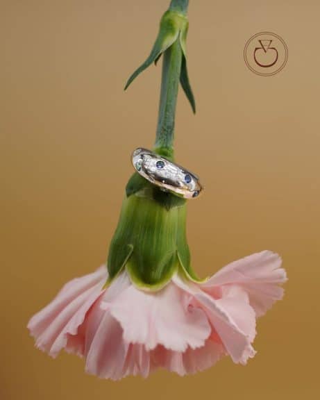 La bague dome en or blanc Alba sertie de saphirs et diamants est sur une fleur